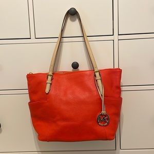 Michael Kors handbag. Carried very little. It is a red orange color. Like new